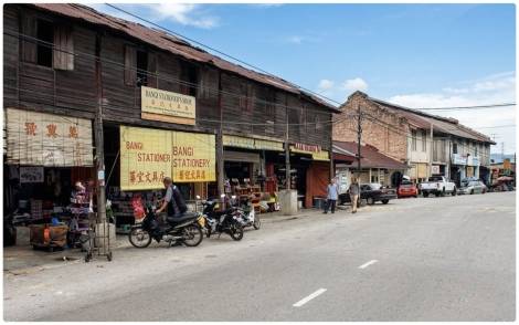 PENDUDUK asal Bangi, Zainal Harun, 76, bersama anaknya, Mohammad Faizal Zainal, 38, menunjukkan sebahagian dari bangunan kedai yang paling awal dan masih lagi ada sehingga kini di pekan Bangi lama. - Foto Kamarulzaman Ariffin